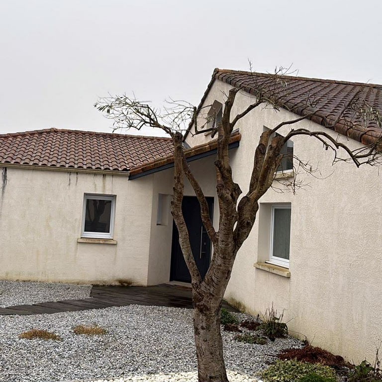 Angle de maison à l’enduit terne, avant les travaux