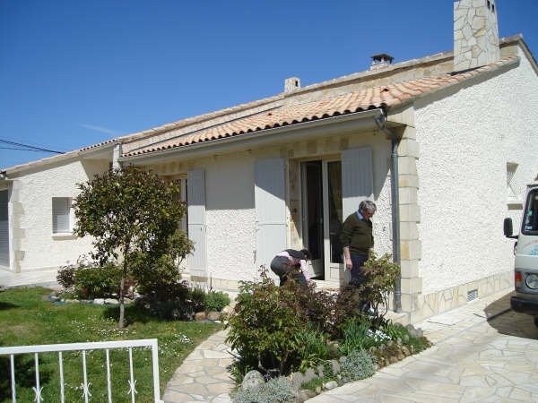 Maison blanche aux volets gris et son jardin