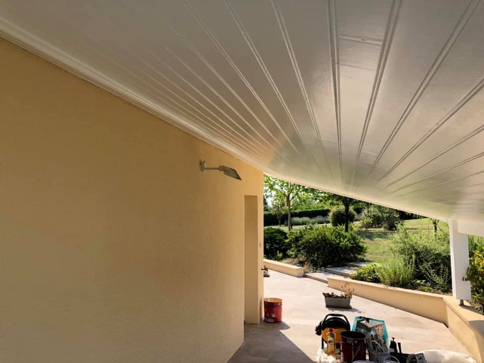 Dessous de toit en lambris blanc au-dessus d’une terrasse