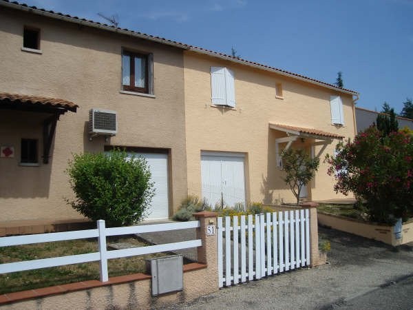 Façade beige et clôture blanche