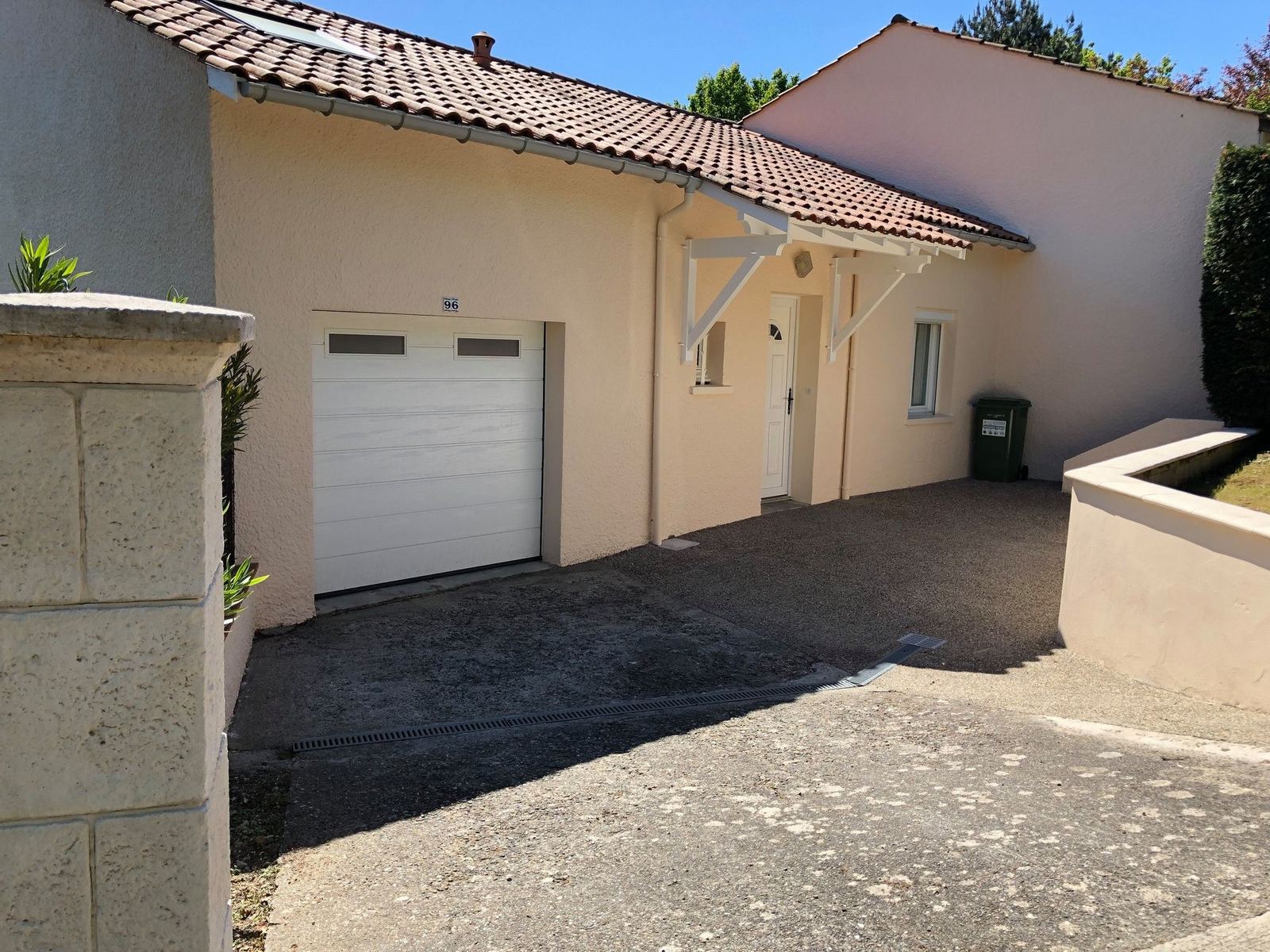 Façade sable et porte de garage blanche