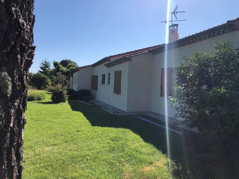 Longue maison blanche et sa pelouse