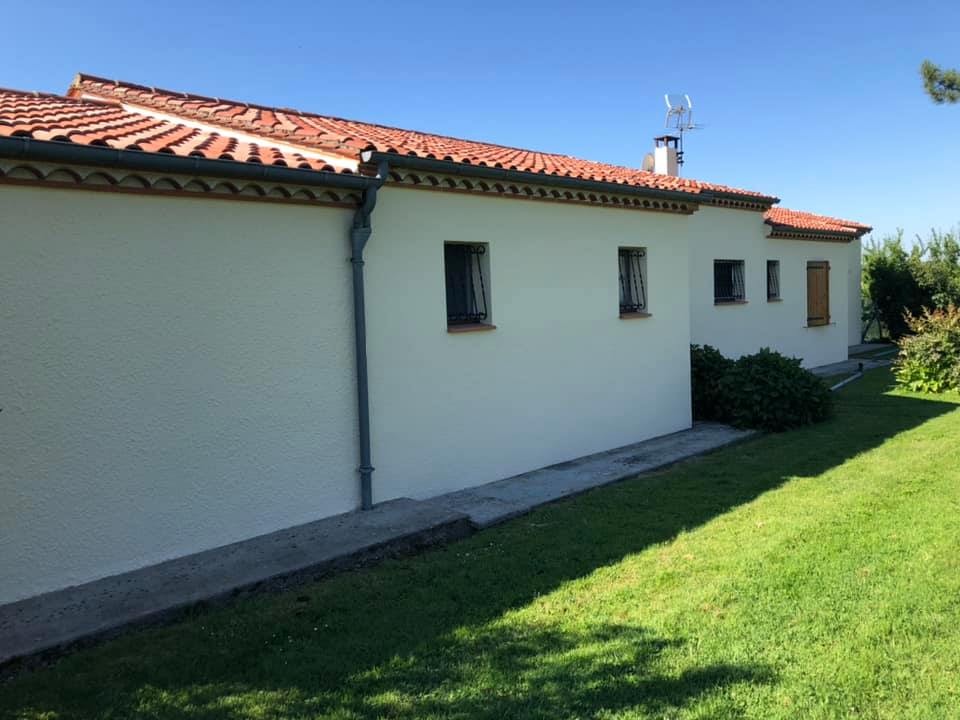 Maison blanche de plain-pied et sa pelouse